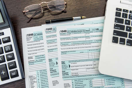 Financial time tax form with laptop and calculator. office paperwork. Accounting