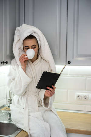 Gorgeous woman relax morning in kitchen and drinking enjoy coffee. Comfort home leisure.の写真素材