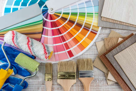 Set of paint tools as color paper palette guide, blue gloves and brush on wooden board. Construction and renovation conceptの写真素材