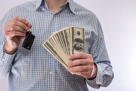 Businessman holding car key and dollar money isolated. sale concept
