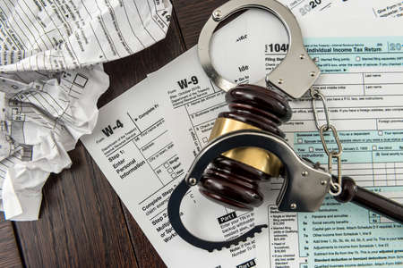Illegal concept USA tax form with gavel and handcuff. Time for business