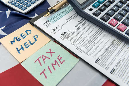 Text need help or tax time on sticker lying different tax form. paperworkの写真素材
