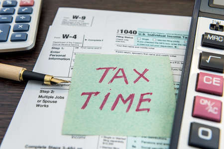 Tax financial forms with pen and calculator and sticker with text Tax Time. Deadline, paper workの写真素材