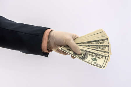 Male hand in medical glove holds us money bills for protection