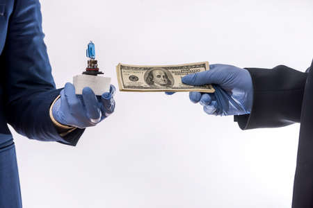 sales in quarantine conditions hands holding car light bulbs and dollar bills isolated. Buying car...