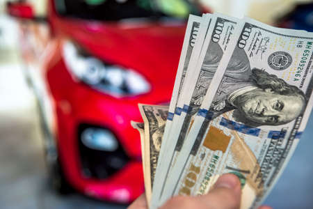 Men holding lot of 100 dollar bills for buy or rent a new car. selling new auto conceptの写真素材