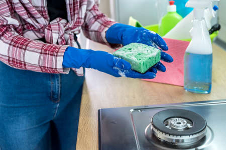 woman doing kitchen cleaning chores with rubber gloves and rag. cleaning conceptの写真素材