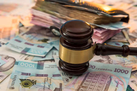 black leather wallet full of Ukrainian hryvnia. 1000 new buyer. The judge's hammer lies on the money. UAH.の写真素材