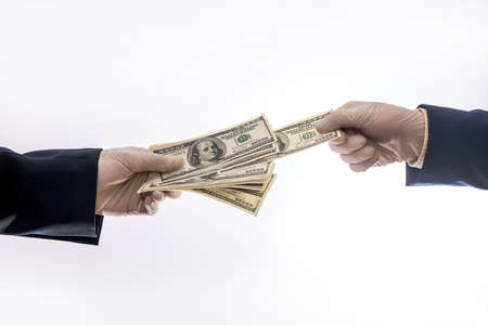 Two hands holding or gives US dollar in medical gloves for protect, quarantine period