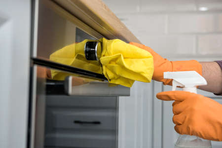 Man's hand in gloves cleaning the kitchen oven. houseworkの写真素材