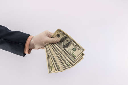 male hand give dollar to pay in protective gloves for safety isolated on white background. medical...