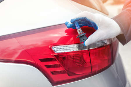 man holding new modern halogen auto bulb for repair. automotive equipmentの写真素材