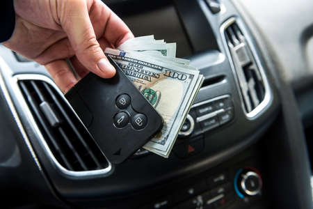 man hold dollar and car key for pay rent or bribe. financeの写真素材