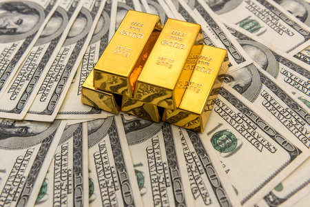 Gold bullion and 100 us money banknotes. financial and economic concept. wealth