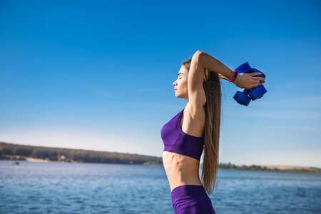 fitness training - beautiful young woman working exercise with dumbbells, as a part of her...