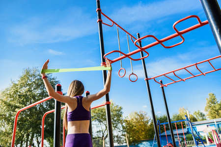 Beautiful slim girl in sport sportswear makes morning exercise at outdoor sportsground. Concept of...