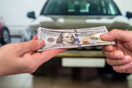 Money to buy the new car. financial concept. dollar in handの写真素材