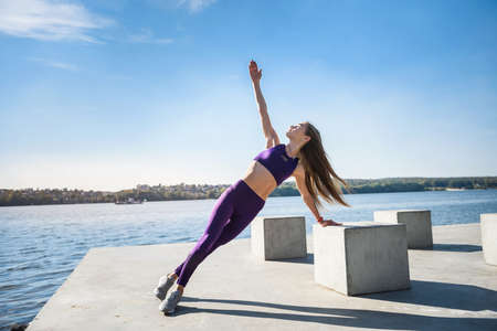 beautiful young woman doing stretching excercise before working time in the morning at parkの写真素材