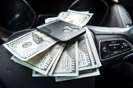 dollars with a car key lie inside cars. financial concept