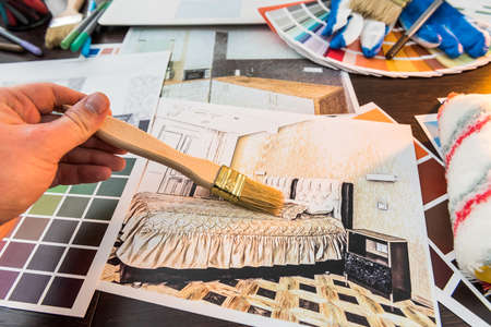 Male hand work with color sampler for design home. Apartament sketch at office deskの写真素材
