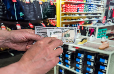 woman but new cloth in store. hand holding dollars. fashion saleの写真素材