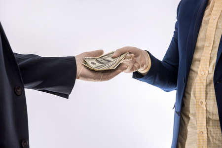 agreement between two businessmen during the virus period, a man in gloves gives money to another...
