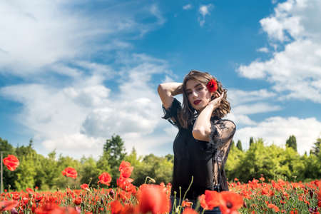 Happy woman in casual cloth at field of poppies enjoy free summer time. natureの写真素材