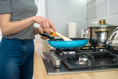 Woman cooking food on kitchen with frying pan on plate, fresh delicious dinner. healthy lifestyleの写真素材