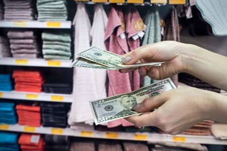 the buy buyers towels for the house and gives dollars to the seller. shopping conceptの写真素材