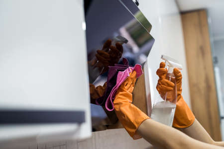 Cleaning kitchen. Female hand washing kitchen hood with sponge. housework