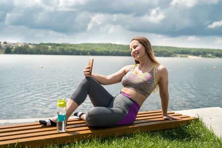 Young slim woman in sportswear sit and relaxing resting after morning sport training. healthy...