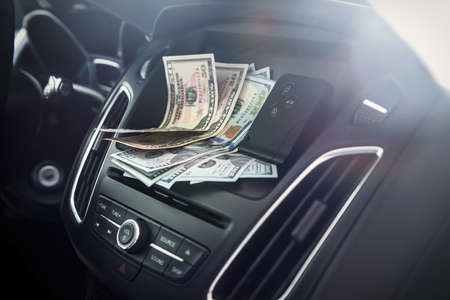 dollars with a car key lie inside cars. financial conceptの写真素材