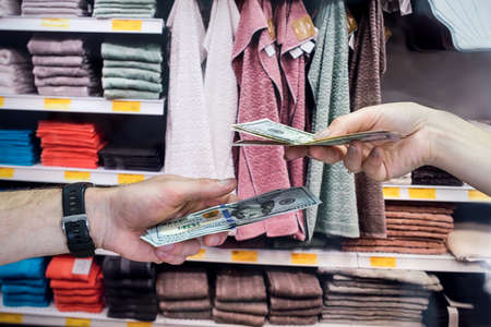 the buy buyers towels for the house and gives dollars to the seller. shopping conceptの写真素材