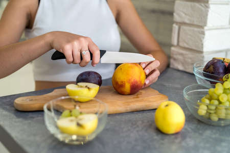 beautiful happy woman on kitchen making fruits salad. healthy food conceptの写真素材