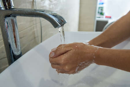 girl washing hands with soap in bathroom for personal hygiene and Covid19 spread prevention.の写真素材