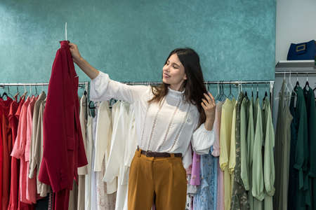 Beautiful young woman choosing jacket at clothes shop. new styleの写真素材