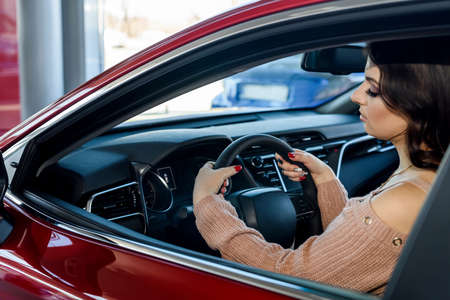 woman sitting in new car in showroomの写真素材