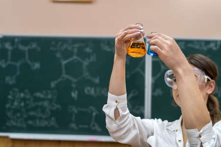 female teacher mixing multi colored chemical liquids together during a chemistry lesson. scientificの写真素材