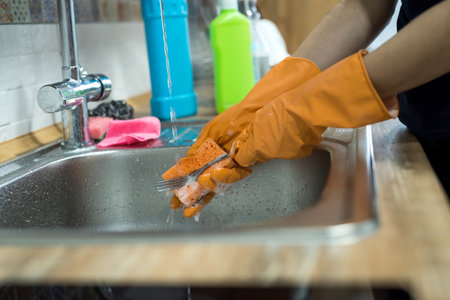 woman hands rinsing plate under running water in the sink. houseworkの写真素材