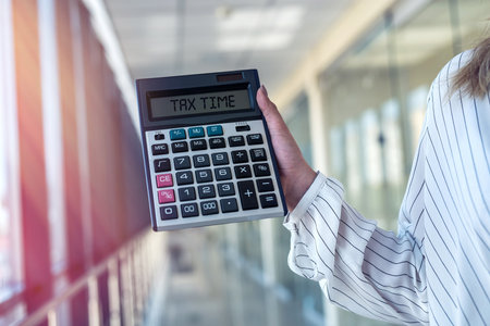 female hand holding calculator in modern business center. finance conceptの写真素材