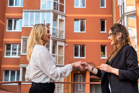 Handshake after success deal between realtor and new owner with house in background. sale conceptの写真素材