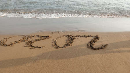 Numbers 2020 year on the sea shore, wave covering lettering. Concept of end awful year of covid19の写真素材