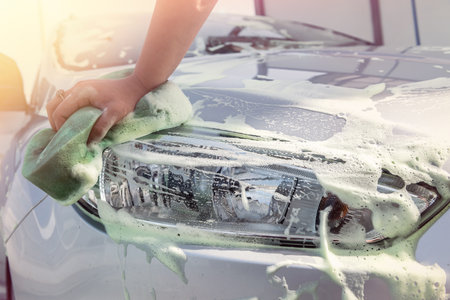 close up of hand washing car with sponge and soap foamの写真素材