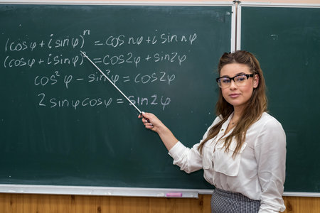 sexy caucasian female teacher against blackboard with mathematical formulas in classroom. Education....