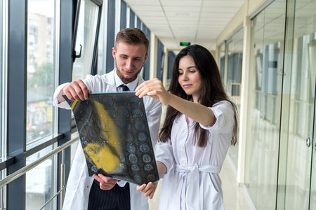 two intern doctors looking MRI of the brain for succses head injury treatment. health conceptの写真素材