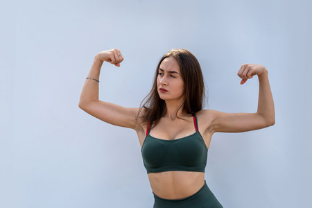 portrait of fitness woman in sportswear posing isolated on gray background. health and sport concept