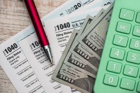 1040 Tax form, calculator and pen us dollars. financial conceptの写真素材