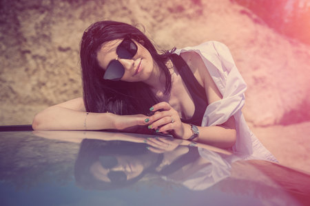 beautiful girl is resting outside the city and posing near the carの写真素材