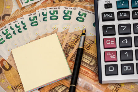 empty note with euro bills pen and calculator in office desk. business conceptの写真素材