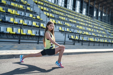 Female athlete doing stretching exercises morning at stadium. concept of sport for health life